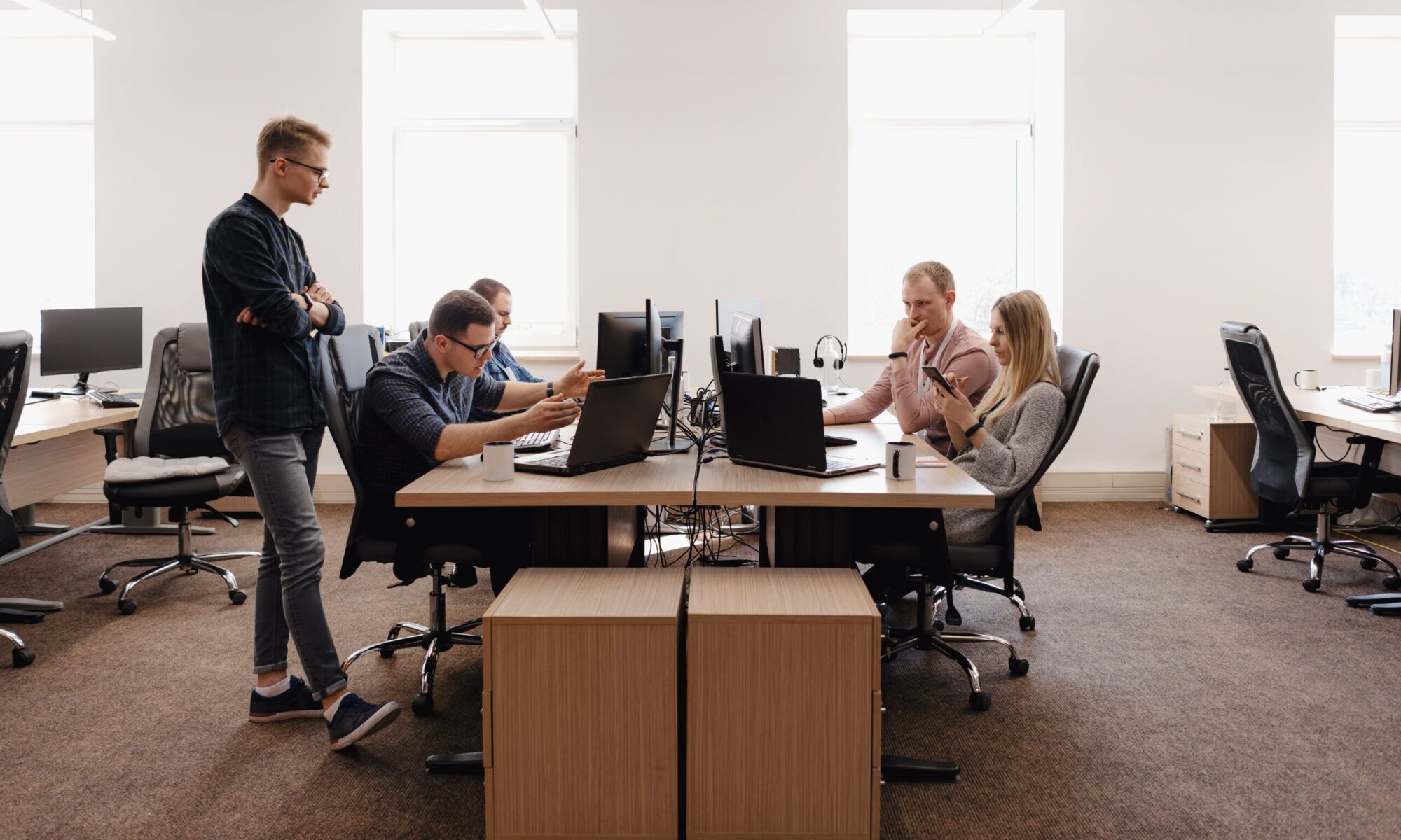 Modern office workspace with employees using rented IT equipment for business productivity in 2026